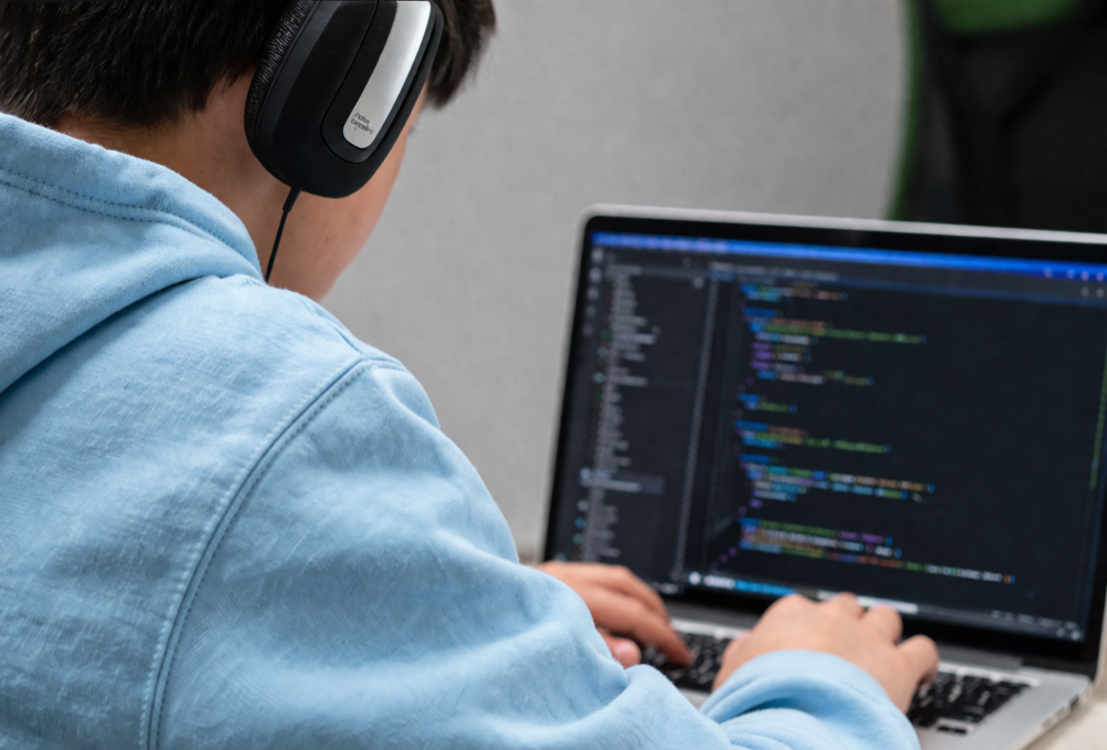 A camper building their app on a laptop